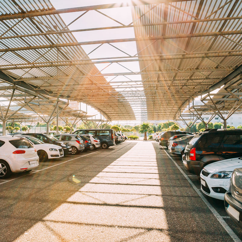 Clean, modern vehicle lineup along the stone driveway of an exclusive golf resort clubhouse, highlighting professional parking logistics for luxury country clubs.